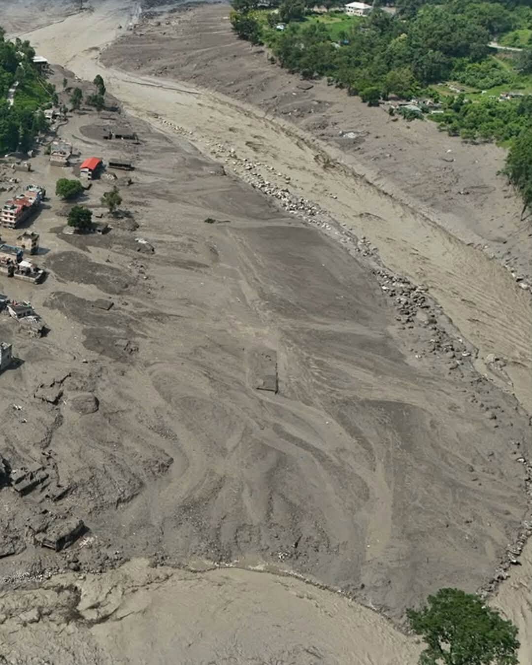 An aerial view of a river valley in Nepal filled with mud and debris.