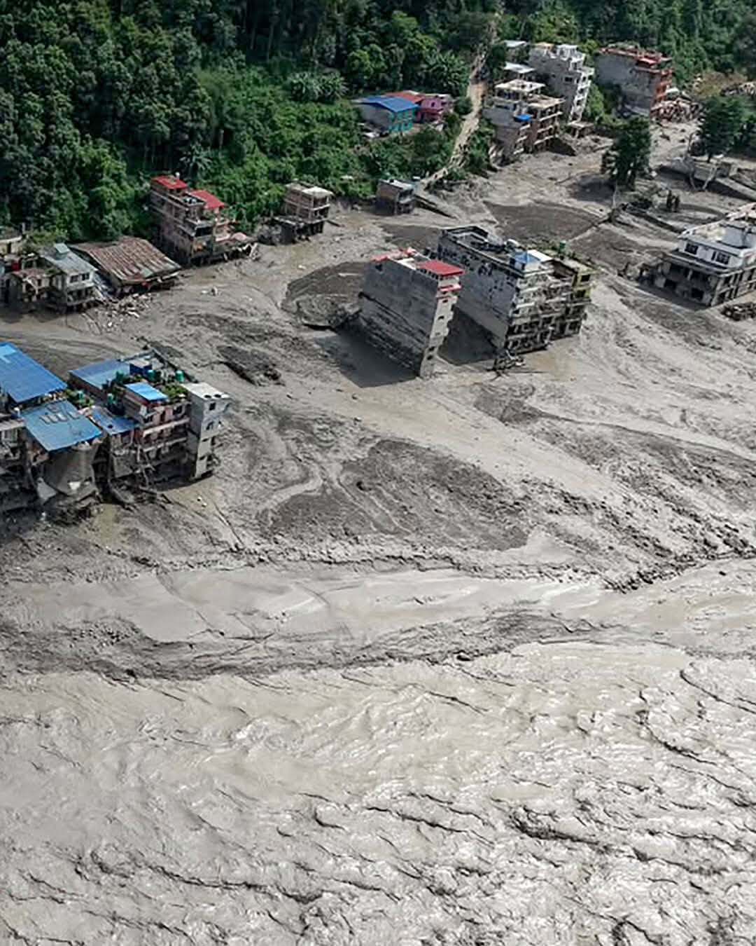 An aerial view of buildings buried in mud along a Nepal riverbank after the flood.